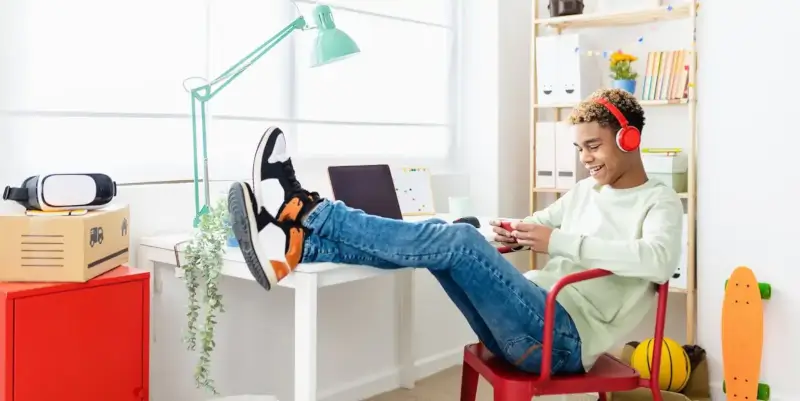 Kluk poslouchá audioknihu na mobilu