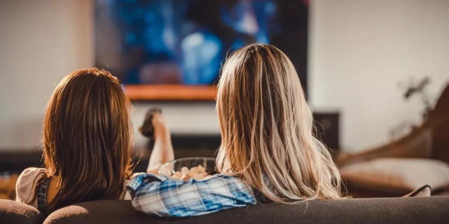 Dvě ženy sledující pořady v televizi.