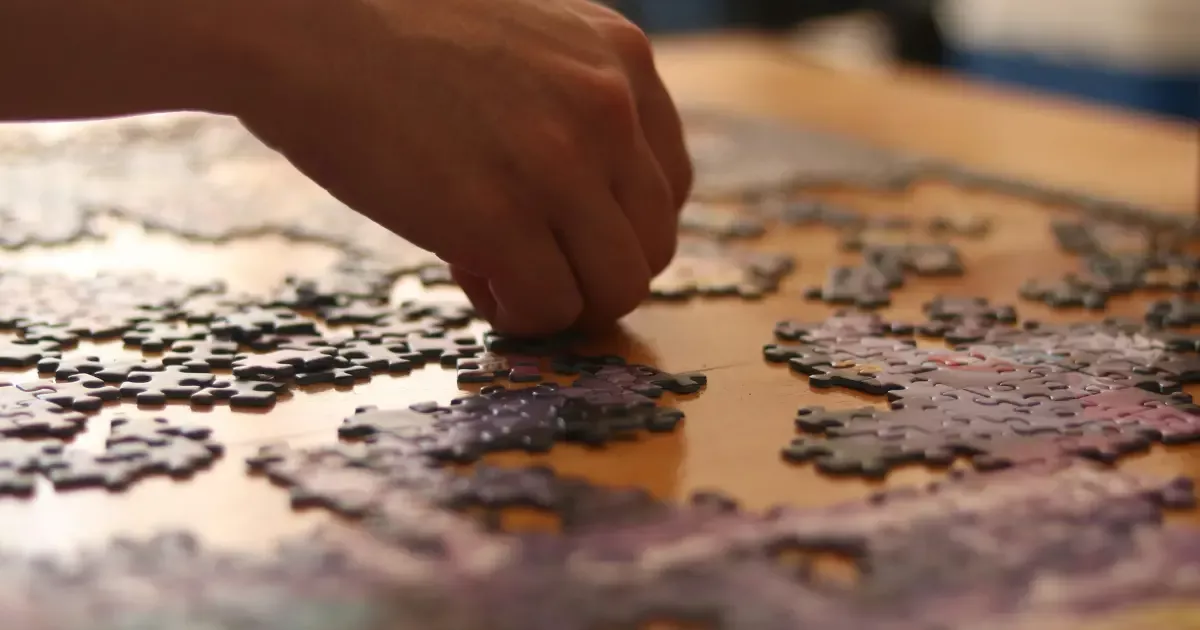 Ruka skládající puzzle.